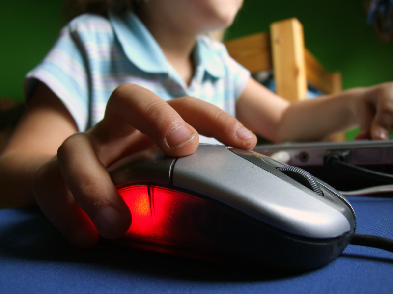 teenage boy clicking on computer mouse