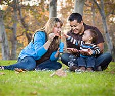 parents blowing bubbles with their child