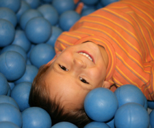 child laying on plastic balls